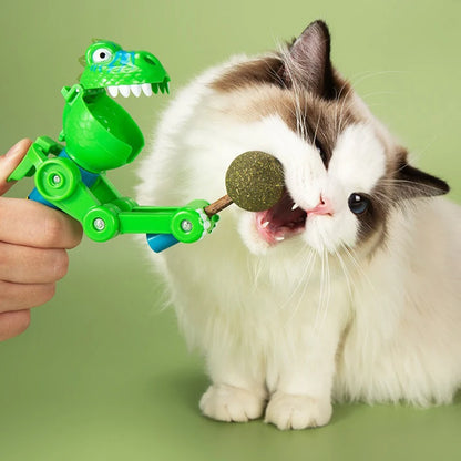 Cat interacting joyfully with a dinosaur lollipop teaser stick on a wooden floor.