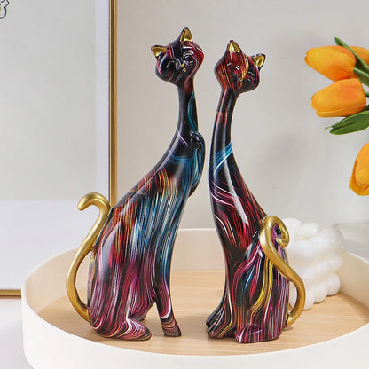 Abstract resin cat figurines in multicolored design on a white background.